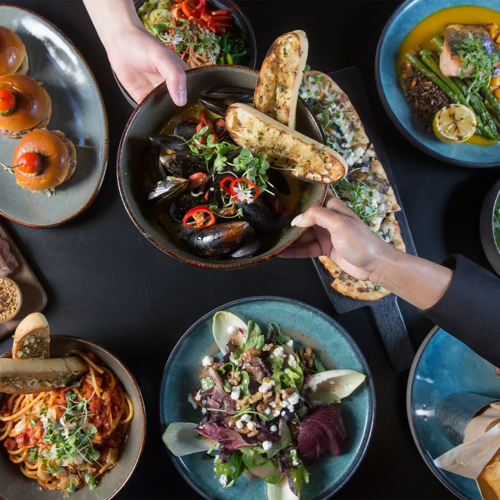 people passing dishes during private dining event at the peel