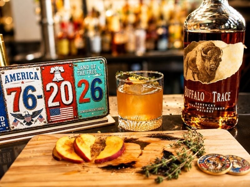 A glass of whiskey and a bottle of Buffalo Trace bourbon next to a patriotic license plate